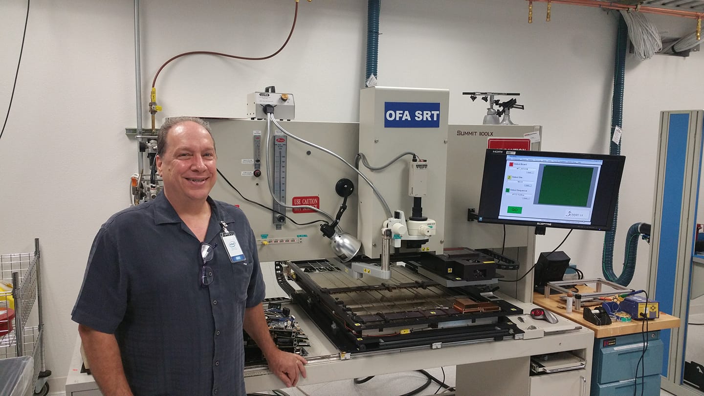 SRT Repair A man standing next to a fully automatic gray BGA rework station with a monitor